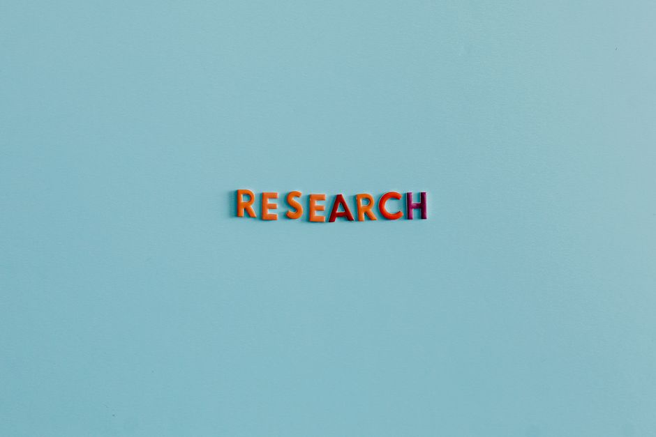 Colourful capital letters spelling the word research on a soft blue background
